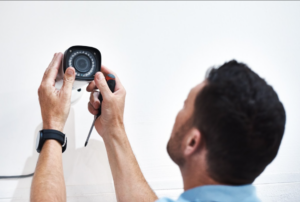 a man is fixing a security camera