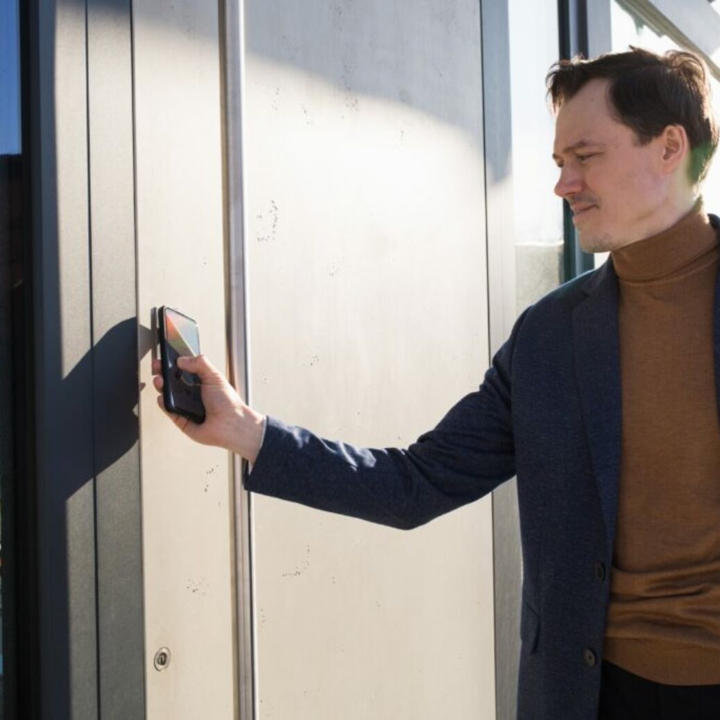 man-person-opens-door-of-house-with-phone-locking-2025-01-16-07-43-20-utc